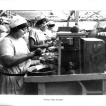 Cannery workers pitting cling peaches.
