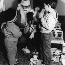 Dennis Andrews plays Santa for children at the Billy DeFrank Center