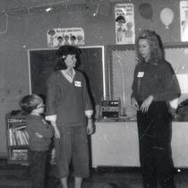Women and a boy at the front of a classroom
