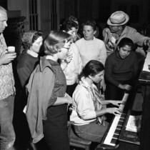 Students gathered around a piano